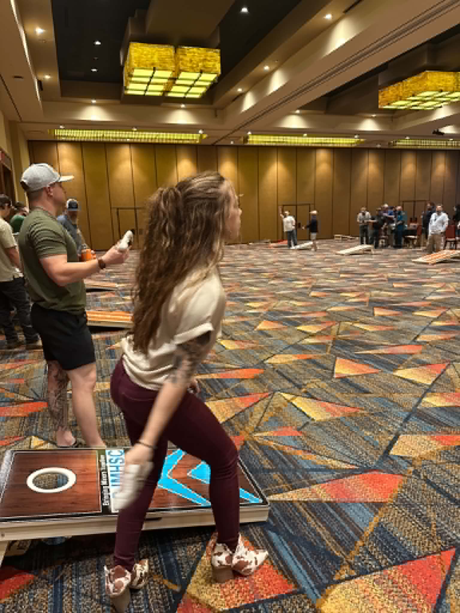 Attendees networking over a game of cornhole at the 2026 conference